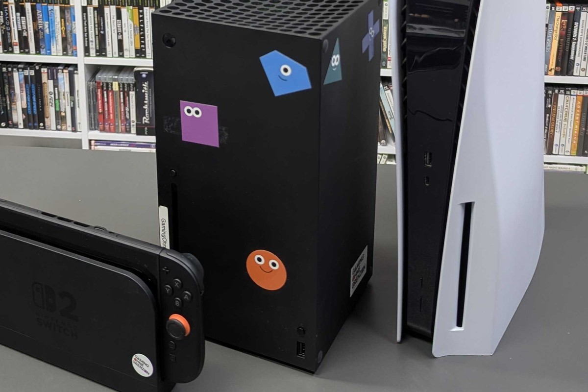 Xbox Series X and PlayStation 5 consoles beside part of a Nintendo Switch 2, photographed in February 2026; hardware context only, not GTA VI gameplay or proof of release.
