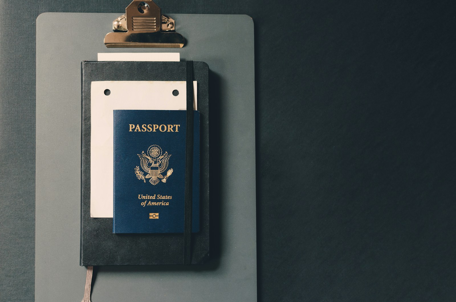 United States passport resting on a clipboard and notebook