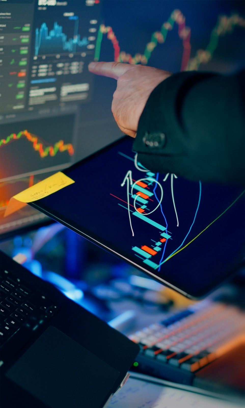 Trader reviewing real market charts across a screen and tablet