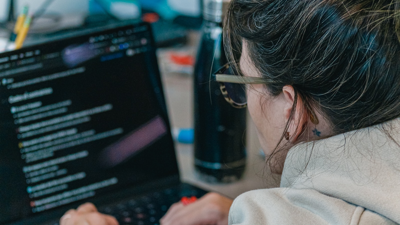 Developer working on a laptop with source code on screen